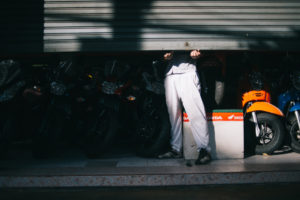 a mechanic opening the door of his shop in the morning